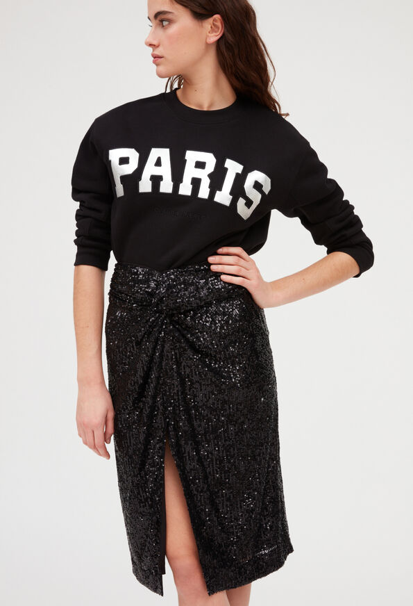 Total look black. Pull à sequins, jupe forme patineuse, jupe à